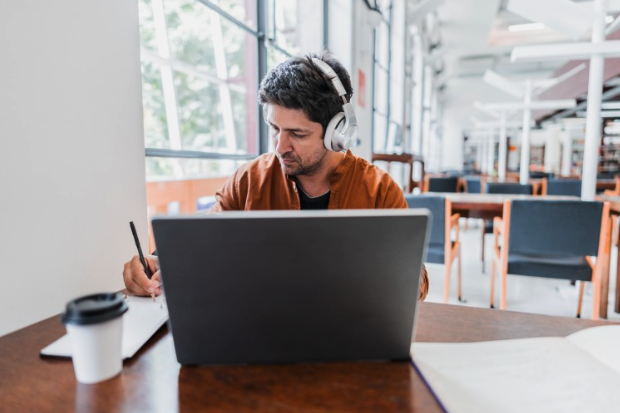 An MBA student studies on a laptop in a library.